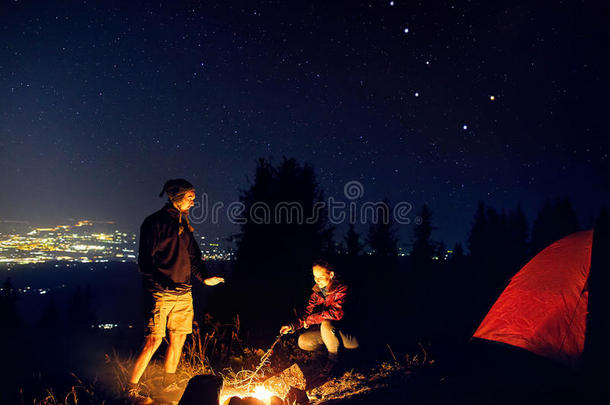浪漫的对在近处营火在布满星星的夜