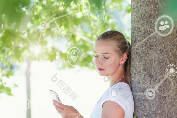 美丽的白肤金发碧眼女人女人使用智能手机采用公园