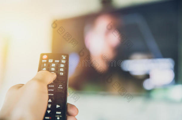 手拿住聪明的电视电视机遥远的控制和一电视