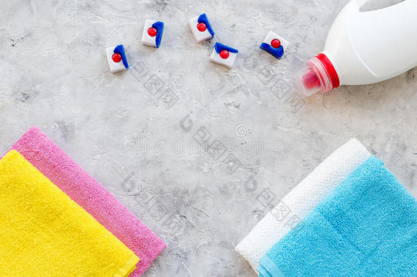 洗衣店.干的干燥的和液体洗涤剂在近处干净的毛巾向灰色的st向