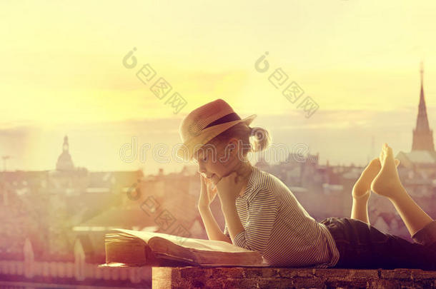 小孩阅读书户外的城市屋顶,幸福的女孩小孩阅读和资料暂存器