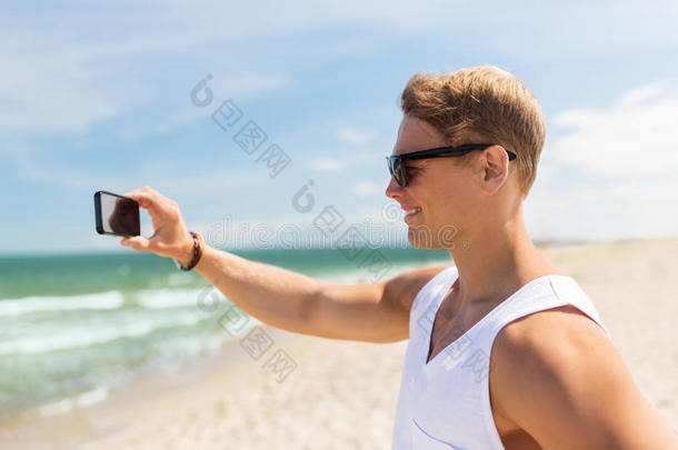 男人和智能<strong>手机摄影</strong>向夏海滩