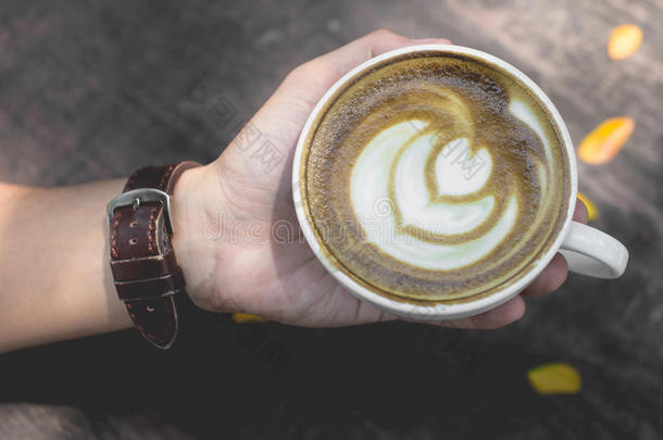 热的绿色的茶水拿铁咖啡艺术向指已提到的人木制的向手