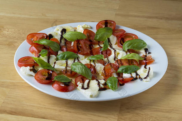 意大利人红白小碟沙拉向白色的盘子番茄罗勒属植物一莫扎雷尔