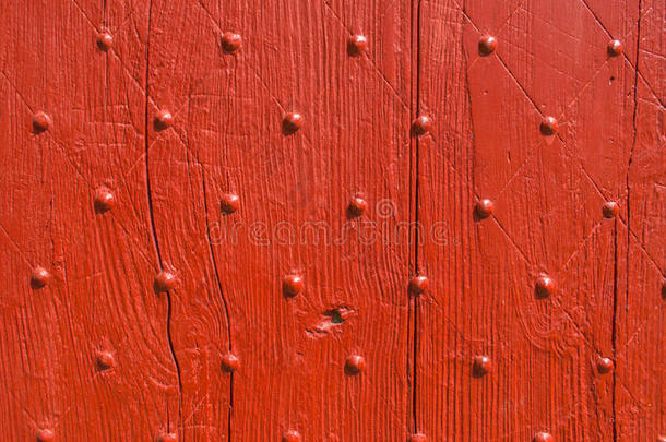 背景质地风化的红色的木制的门和钉子装饰