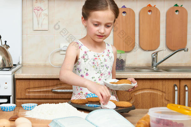 女孩烘焙甜饼干.家厨房内部.健康的食物观念