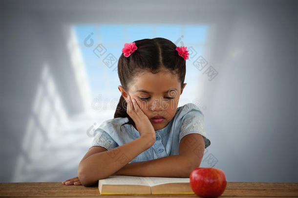 混合成的影像关于集中的女孩阅读书在书桌