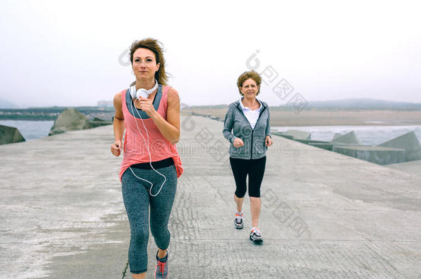 较高的和年幼的女运动家跑步