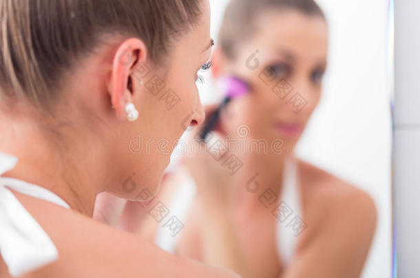 女人分型粉她面容和化妆品刷子