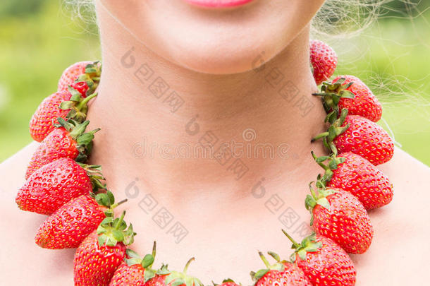 <strong>美</strong>丽的微笑的女人颈和红色的小珠子使关于新鲜的稻草