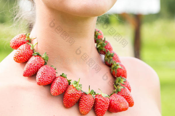 美丽的女人颈和红色的小珠子使关于新鲜的草莓