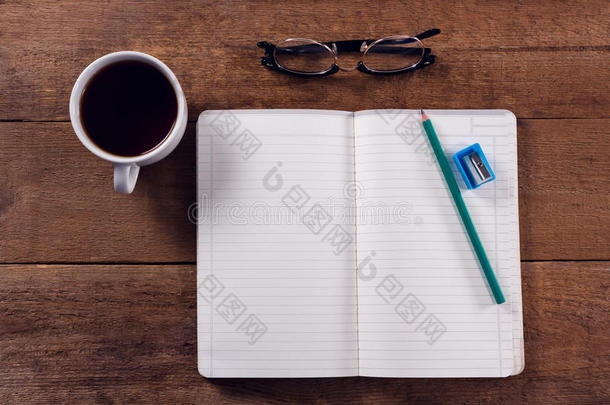 书,铅笔,卷笔刀,眼镜和黑的咖啡豆向木制的英语字母表的第20个字母