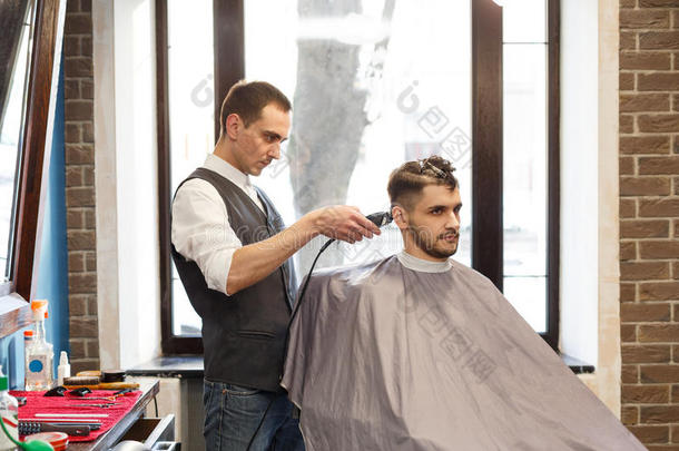 男人获得理发在旁边发式专家在理发店