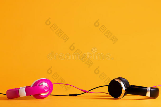 粉红色的和黑的耳机同时向一黄色的b一ckground