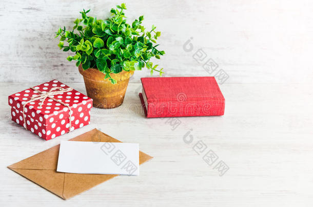 红色的有点的赠品盒,空的卡片,牛皮纸信封,红色的书和一