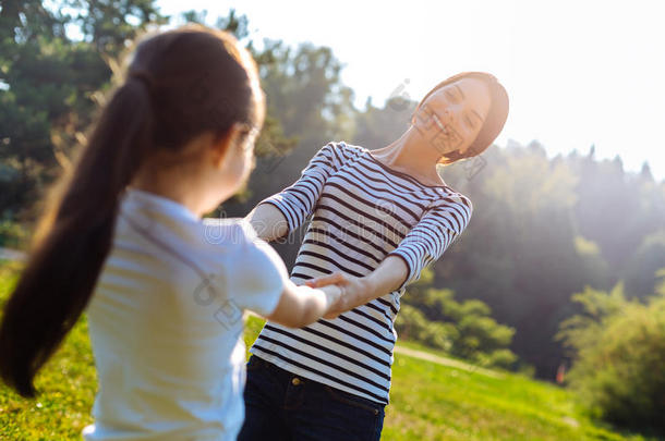 幸福<strong>的</strong>母亲纺纱她女儿在户外