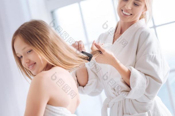 高兴的女人梳毛长的头发关于她小孩