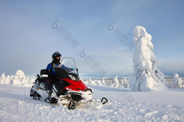 男人操纵摩托雪橇采用下雪的mounta采用山谷
