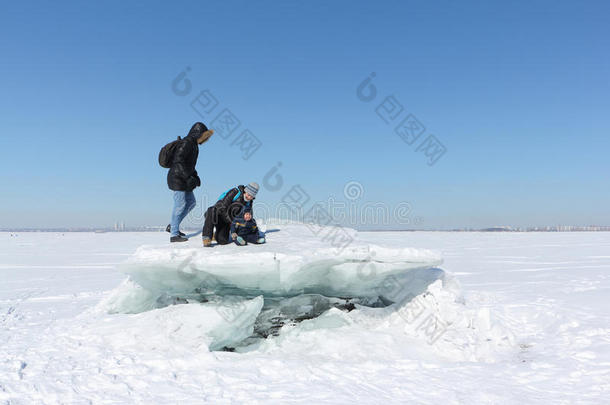 男人,女人和小孩步行向一冰大浮冰向一下雪的河