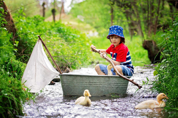 漂亮的小孩,男孩,演奏和小船和鸭向一小的河