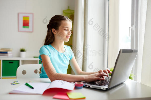 幸福的女孩打字向便携式电脑在家
