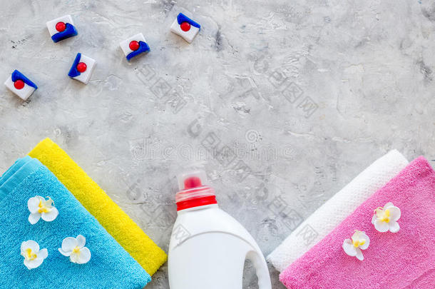 洗衣店.干的干燥的和液体洗涤剂在近处干净的毛巾向灰色的st向
