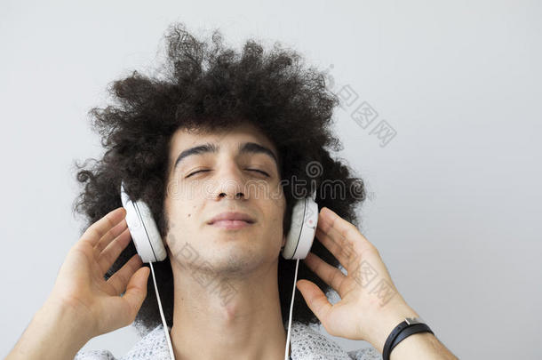 年幼的男人收听的音乐和耳机