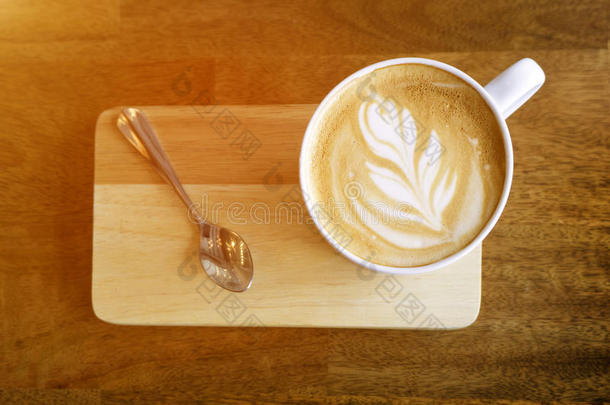 热的拿铁咖啡咖啡豆向木制的表.