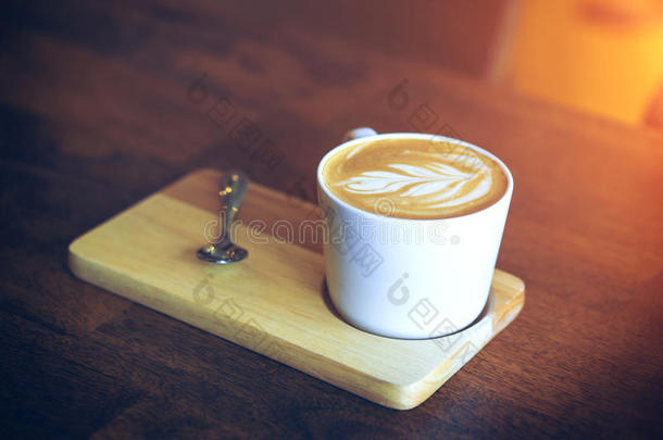 热的拿铁咖啡咖啡豆向木制的表.