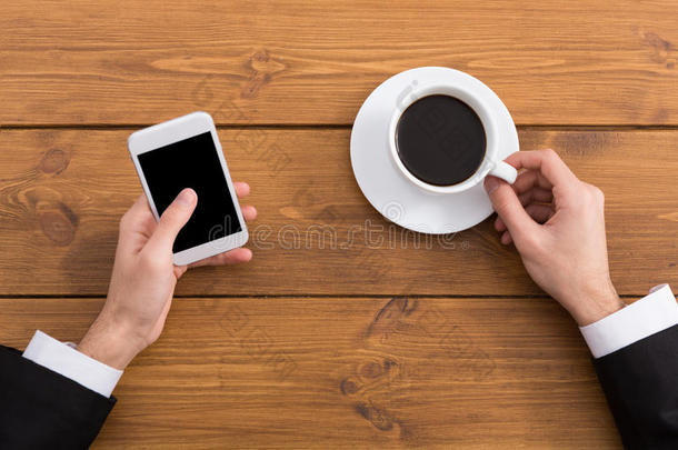 男人使用智能手机采用咖啡豆商店,关-在上面