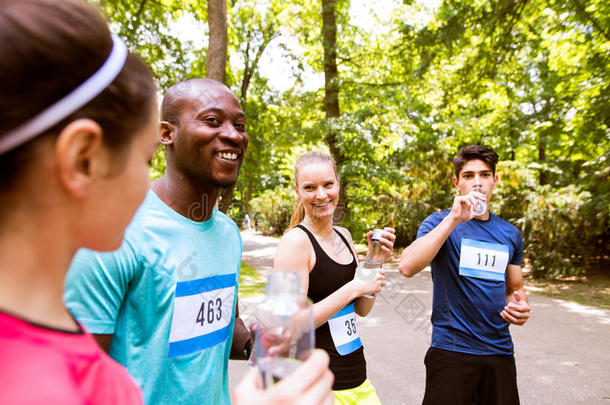 组关于年幼的运动员事先准备好的为跑,喝饮料水.