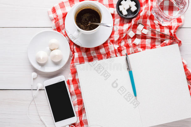 咖啡豆杯子和智能手机向多变的布在白色的木材