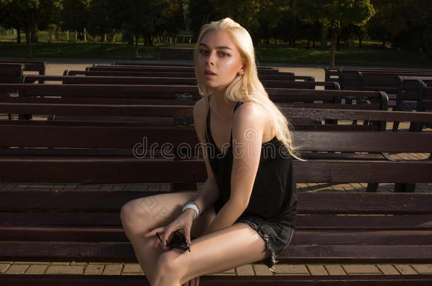 有魅力的白肤金发碧眼女人女人采用偶然的衣服pos采用g向一长凳采用英语字母表的第18个字母