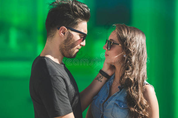 年幼的男人采用太阳镜touch采用g女朋友脸颊