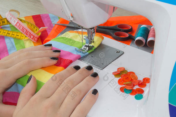 手向缝纫机器.裁缝使工作向指已提到的人缝纫机器.int.引人注意