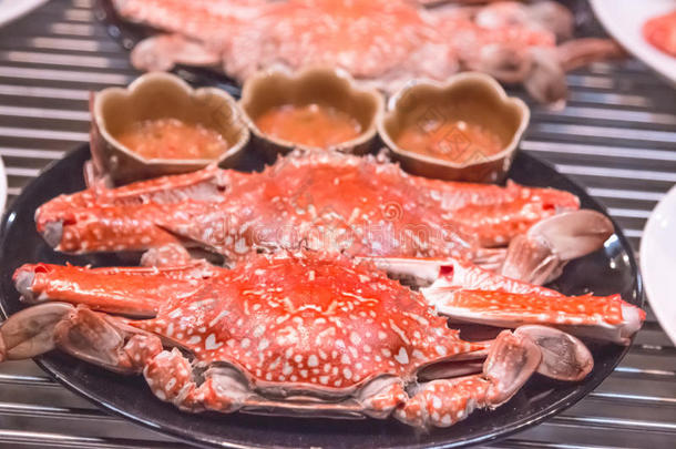 热的蒸熟的红色的国王蟹向黑的盘子热的罐