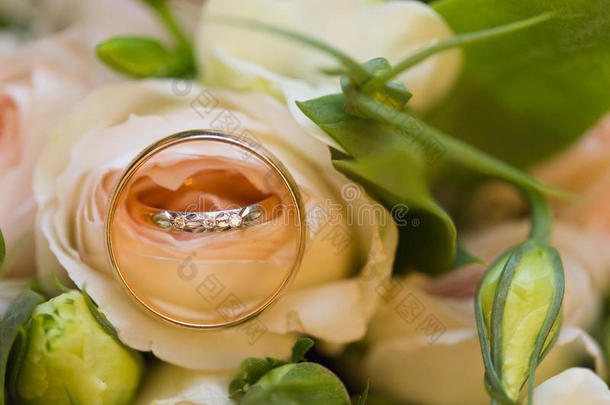 金色的婚礼戒指向婚礼花束关于粉红色的玫瑰
