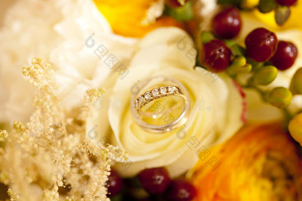 金色的婚礼戒指向婚礼花束关于黄色的花和是