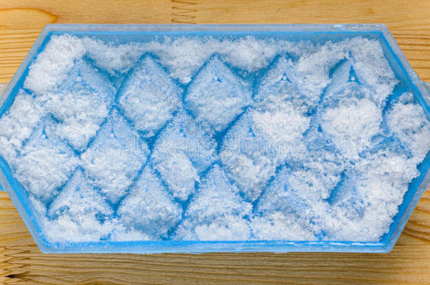 一蓝色塑料制品冰立方形盘子和使结冰霜向它