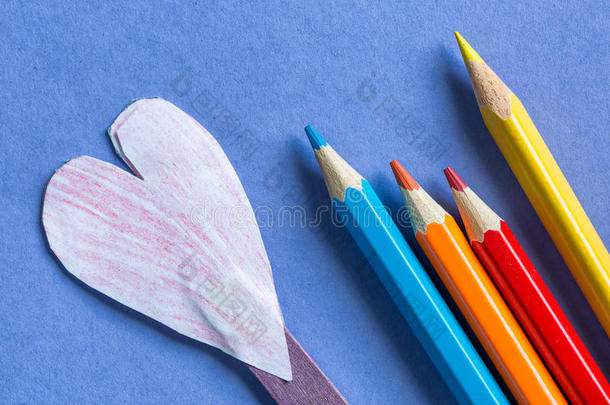 有色的铅笔和纸听到向蓝色纸背景