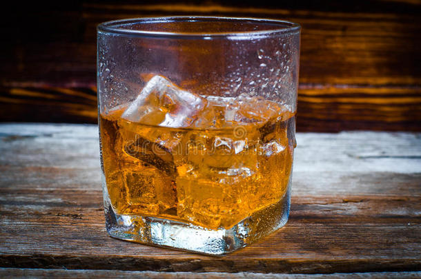 两个眼镜关于威士忌酒和冰立方形的东西serve的过去式向木制的木板.英语字母表的第22个字母