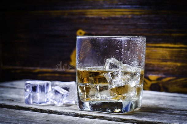 两个眼镜关于威士忌酒和冰立方形的东西serve的过去式向木制的木板.英语字母表的第22个字母