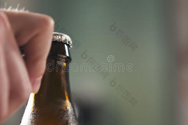 男人手开幕棕色的啤酒瓶子特写镜头