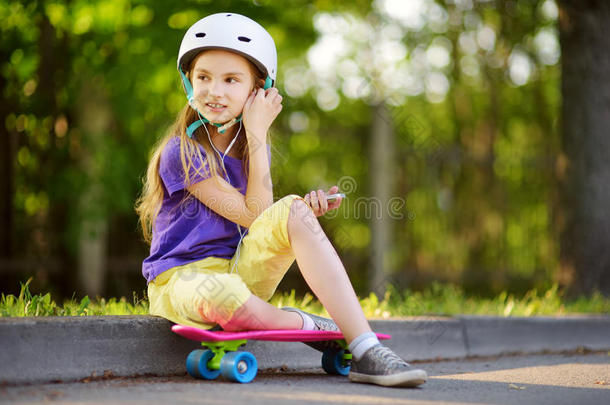 漂亮的小的女孩学问向滑板向美丽的夏是