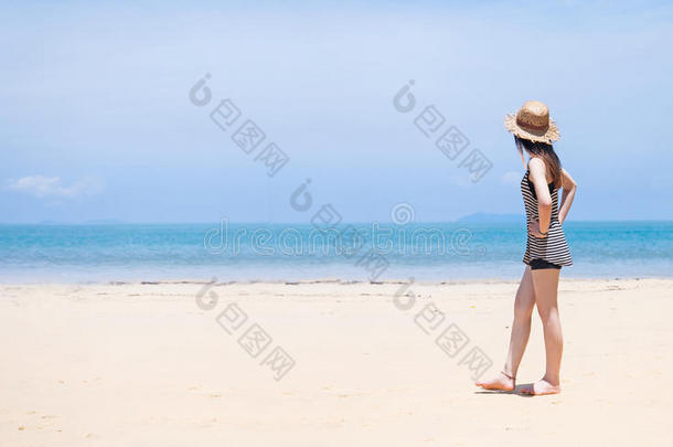女人和海滩帽子向热带的海滩