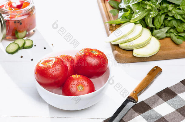 罐装的番茄和新鲜的番茄向白色的背景