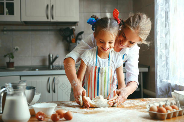 幸福的家庭母亲和女儿烤捏炼生面团采用厨房