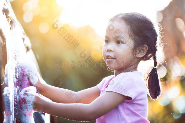 幸福的亚洲人小孩女孩所有乐趣向<strong>帮助父亲</strong>洗涤汽车