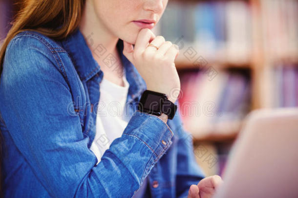学生和智能手表使用便携式电脑采用图书馆