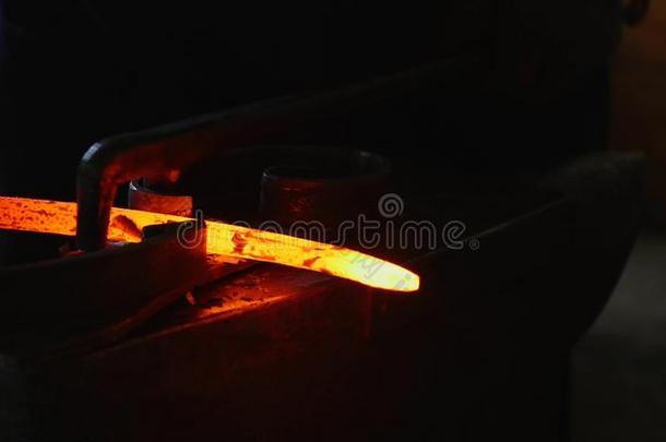 铁匠工作的和热的灼热的金属,弯曲钢采用一same同样的